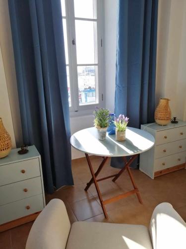 a living room with a table with two plants on it at Aegina Port Apt 4 in Egina