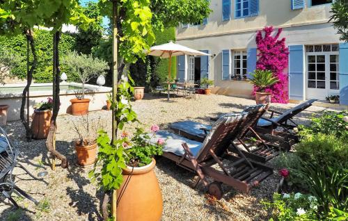 - une cour avec 2 chaises et un parasol dans l'établissement Lintimiste, à Paradou