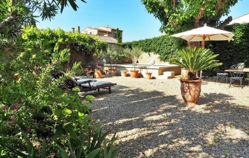 - un jardin avec un banc et un parasol dans l'établissement Lintimiste, à Paradou