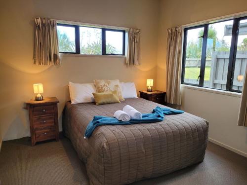 a bedroom with a bed with two towels on it at Station Lodge in Ohakune