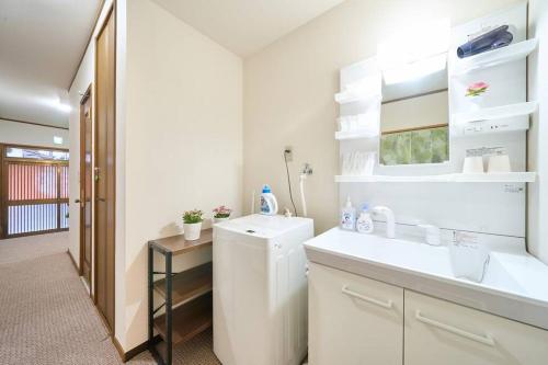 een badkamer met een wastafel en een wasmachine bij 花の宿　別府・鉄輪 in Beppu