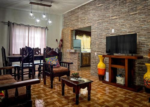sala de estar con TV y pared de ladrillo en Casa de campo - Ruta Turquesa, en El Naranjo