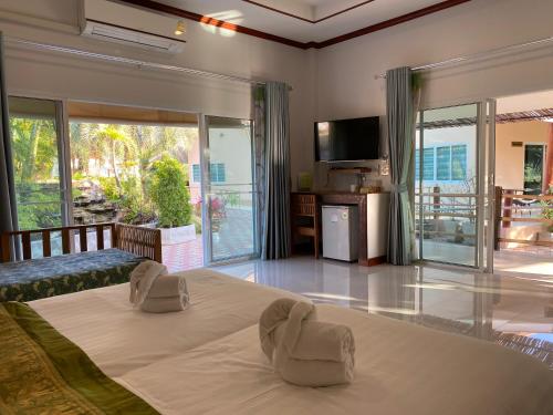 a large bedroom with a large bed with two chairs at Chang Noi Hua Hin Pranburi fully accessible barrierefrei resort in Ban Nong Sua