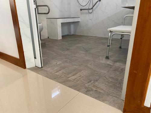 a bathroom with a tile floor and a table and chair at Chang Noi Hua Hin Pranburi fully accessible barrierefrei resort in Ban Nong Sua