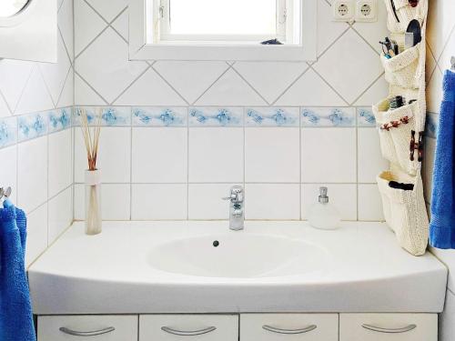 a white bathroom with a sink and a window at Holiday home NORRTÄLJE IV in Norrtälje