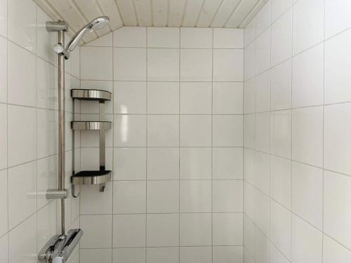 eine weiß geflieste Dusche mit Duschkopf in der Unterkunft Holiday home NORRTÄLJE VI in Norrtälje