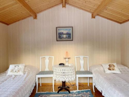 a room with two beds and a table with a dog laying on them at Holiday home NORRTÄLJE VI in Norrtälje