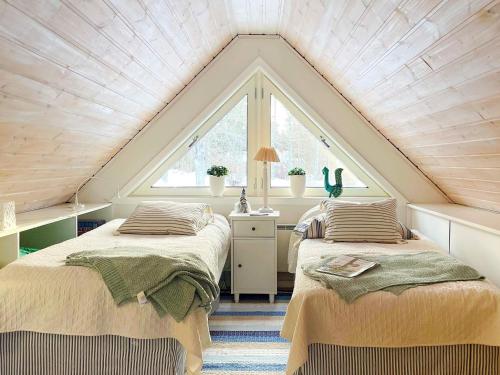 um quarto no sótão com 2 camas e uma janela em Holiday home NORRTÄLJE IV em Norrtälje