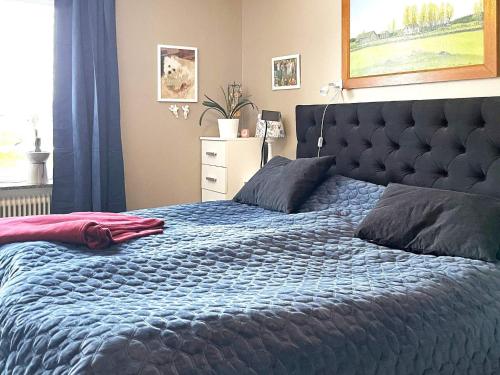 1 dormitorio con 1 cama con edredón azul en Holiday home HÄLLEKIS, en Lugnås