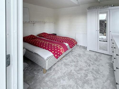 una camera da letto con un letto con una coperta rossa sopra di 4 star holiday home in VINTROSA-By Traum a Vintrosa