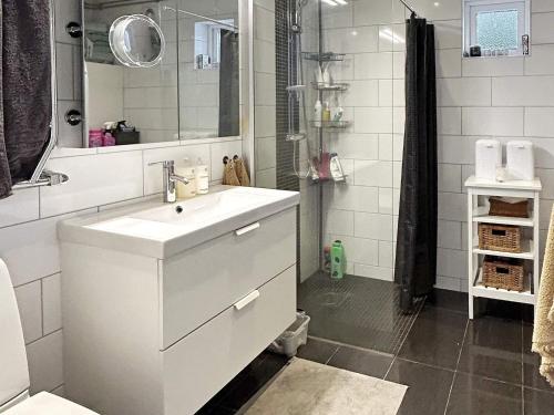 un bagno bianco con lavandino e doccia di 4 star holiday home in VINTROSA-By Traum a Vintrosa