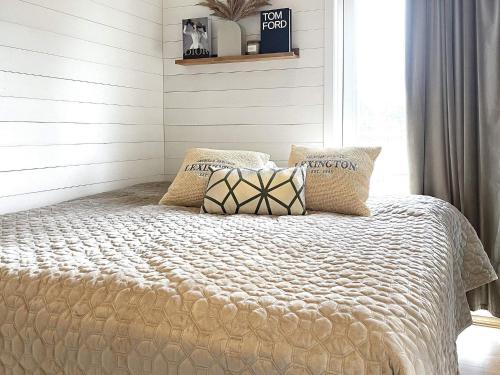 Holiday home UDDEVALLA XIX في Sundsandvik: سرير في غرفة نوم بجدران بيضاء