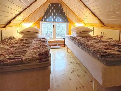 2 Betten in einem Zimmer mit Fenster in der Unterkunft Holiday home Ronneby XIII in Ronneby