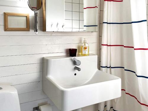 a white sink in a bathroom with a shower curtain at Holiday home Linköping II in Linköping