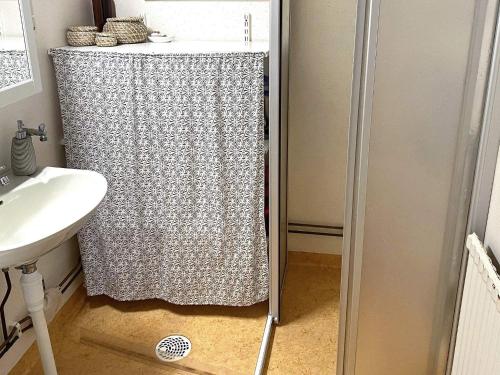 a bathroom with a shower curtain next to a sink at Holiday home Idre VII in Idre