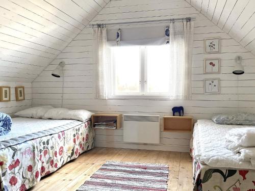 2 Betten in einem Dachzimmer mit Fenster in der Unterkunft Holiday home Linköping II in Linköping