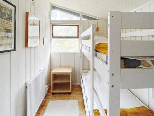 a small room with two bunk beds and a window at Holiday home GRISSLEHAMN XIV in Grisslehamn
