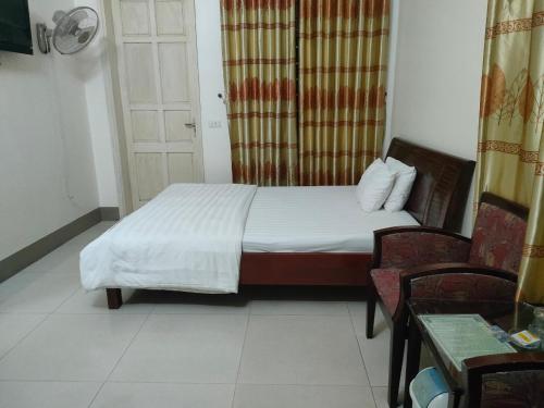 1 dormitorio con 1 cama, 2 sillas y puerta en khach san viet uc en Vinh