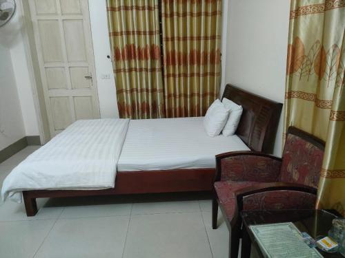 1 dormitorio pequeño con 1 cama y 1 silla en khach san viet uc en Vinh