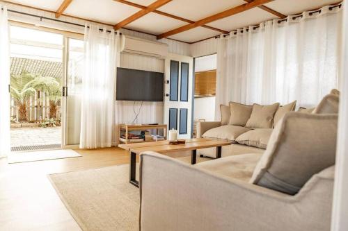 a living room with a couch and a tv at Bay Breeze - Boat - Bike - Hike in St Helens
