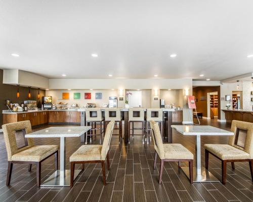 a restaurant with tables and chairs and a kitchen at Comfort Suites Woodland - Sacramento Airport in Woodland