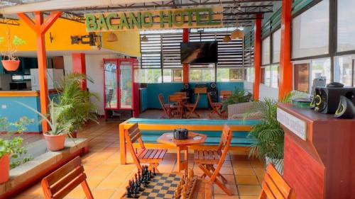 um restaurante com mesa e cadeiras e uma sala de jantar em Aparta Hotel Bacano Historico em Santa Marta