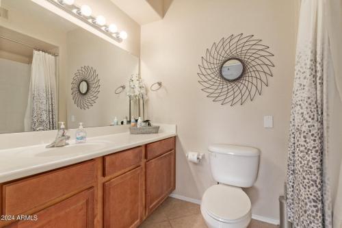 een badkamer met een wastafel, een toilet en een spiegel bij Elegant Scottsdale Condo - Newly Refurbished Ground Floor Unit in Scottsdale