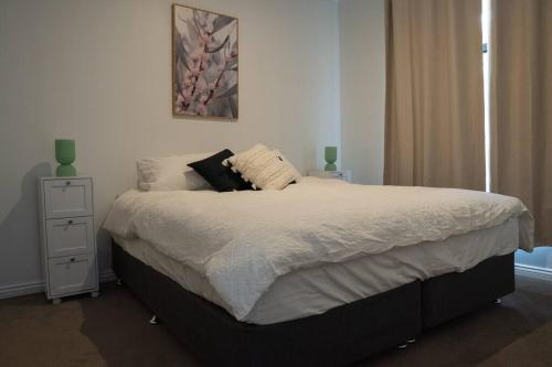 een slaapkamer met een groot bed en een nachtkastje bij Goldfields Hideaway in Kalgoorlie