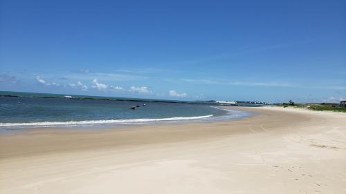 a beach with people swimming in the ocean at Casanostra44 in Jenipabu