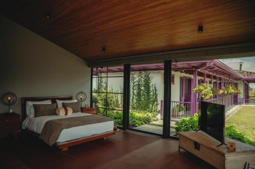 - une chambre avec un lit et une télévision dans l'établissement La Casa en las Nubes, à Salento