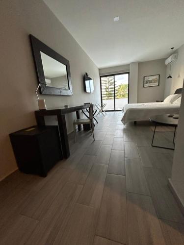 1 dormitorio con cama, escritorio y espejo en Suites Athos4, en Cancún