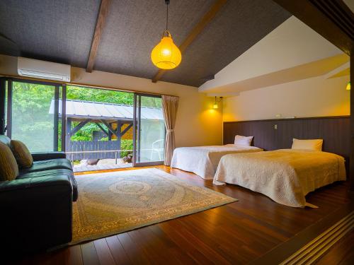 1 Schlafzimmer mit 2 Betten und einem Sofa in der Unterkunft Spagreenness in Kokonoe