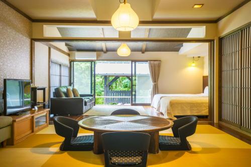 a hotel room with a bed and a table and chairs at Spagreenness in Kokonoe