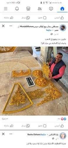 Um homem está a olhar para uma exibição de jóias douradas. em شارع السودان em Cairo