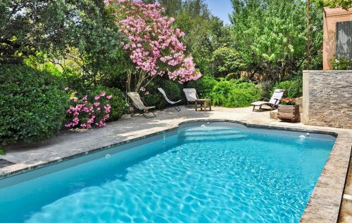 - une piscine dans une cour agrémentée de chaises et de fleurs dans l'établissement Saint Benoit 3, à Villeneuve-lès-Avignon