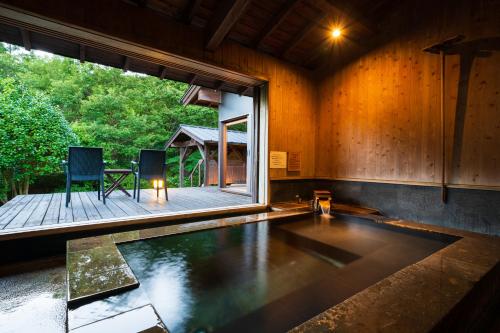 a room with a swimming pool and a large window at Spagreenness in Kokonoe