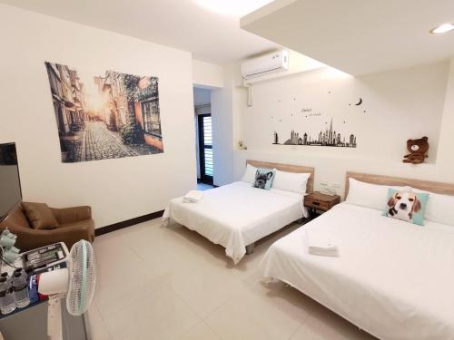 a bedroom with two beds and a couch at Henchun Hope Homestay in Hengchun South Gate