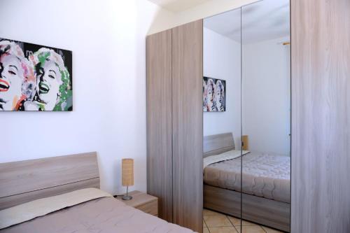 1 dormitorio con cama y armario de cristal en Le Residenze Salentine - Case Vacanza in Lecce, en Lecce