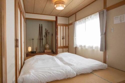 a large bed in a room with a window at カムイ・スキーロッジ in Fukagawa