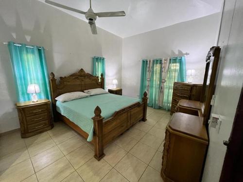 a bedroom with a bed and a ceiling fan at Casa Amplia con Piscina in San Felipe de Puerto Plata