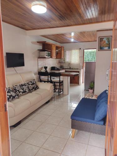 a living room with a couch and a kitchen at Departamento Ángeles del Arenal #1 in Fortuna