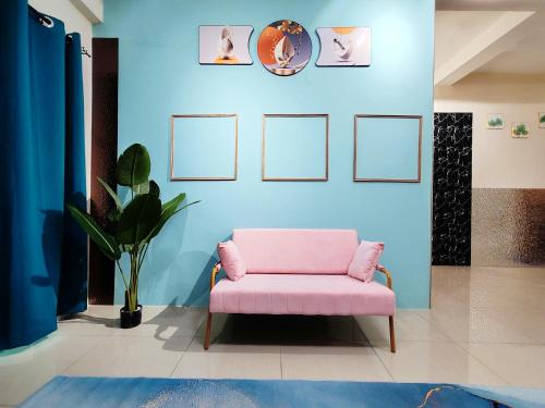 a pink chair in a room with a blue wall at Pavilionvillie M1T696 by irainbow in Ipoh