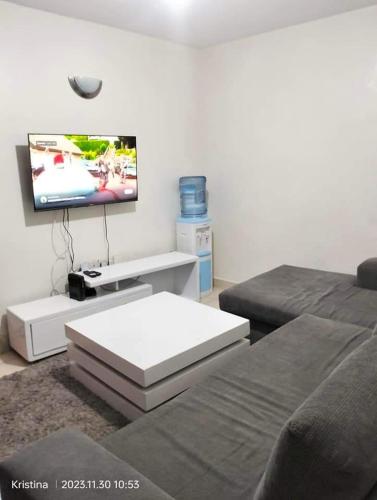 uma sala de estar com um sofá e uma televisão de ecrã plano em Nairobi Airbnb em Nairobi