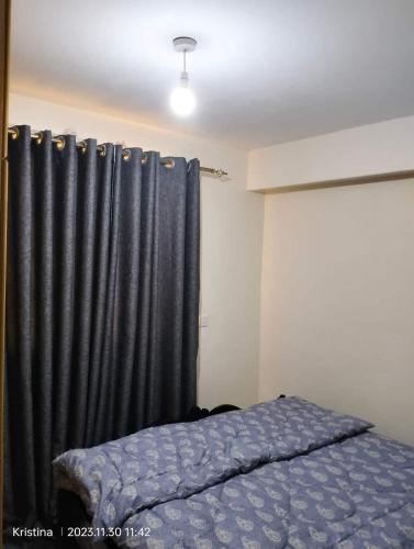 um quarto com uma cama e uma cortina preta em Nairobi Airbnb em Nairobi