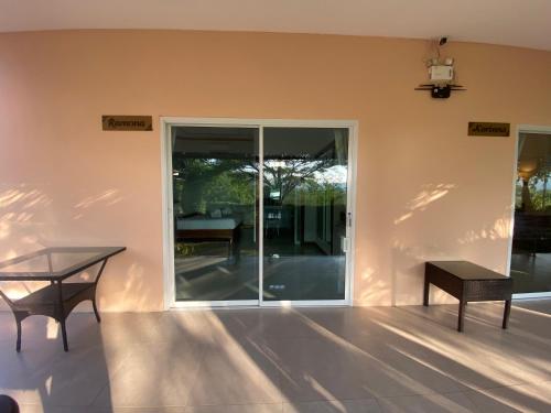 a patio with a table and a glass door at Chang Noi Hua Hin Pranburi fully accessible barrierefrei resort in Ban Nong Sua