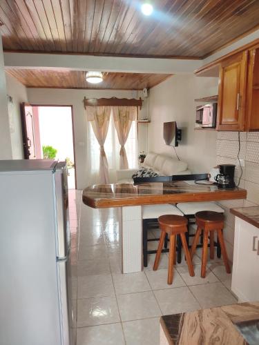 a kitchen with a table and stools in a room at Departamento Ángeles del Arenal #1 in Fortuna