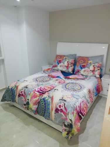 a bed with a colorful comforter and pillows on it at Holiday Dream port Ghalib in Abu Dabab