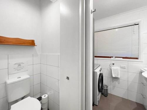 une salle de bains blanche avec toilettes et lavabo dans l'établissement Banksia Cottage, à Halls Gap