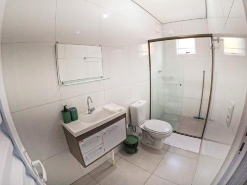 a white bathroom with a shower and a toilet at Baru Bonito - Suítes in Bonito