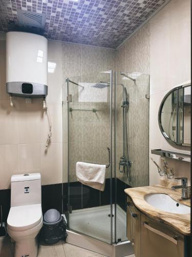 uma casa de banho com um chuveiro, um WC e um lavatório. em CITY GARDEN HOTEL em Dushanbe